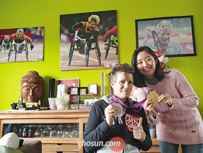 휠체어 육상 선수 마리케 베르보트(왼쪽)가 지난달 벨기에 디에스트에 있는 자신의 집에서 탐험대원 남혜윤씨를 만나 패럴림픽 메달을 들어 보이고 있다.