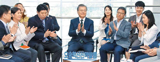 신약 개발 기업인들 만난 文대통령 - 문재인(가운데) 대통령이 22일 충북 오송 첨단의료산업진흥재단 신약개발지원센터에서 ‘오송 혁신 신약살롱’ 관계자들의 의견을 듣고 손뼉을 치고 있다. ‘오송 혁신 신약살롱’은 신약 개발을 목적으로 하는 기업인 등이 주도해서 만든 모임이다. 문 대통령은 앞서 ‘민관 합동 바이오헬스 국가비전 선포식’에 참석해 “2030년까지 제약·의료 기기 세계시장 점유율 6%, 500억달러 수출을 달성하고 (바이오헬스를) 5대 수출 주력 산업으로 육성하고자 한다”고 말했다.