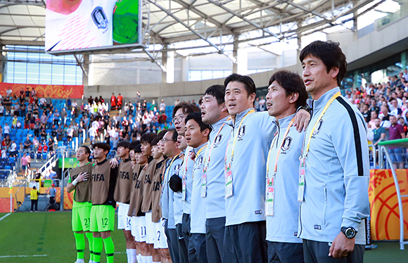 4일 오후(현지시간) 폴란드 루블린 경기장에서 열린 2019 국제축구연맹(FIFA) 20세 이하(U-20) 월드컵 16강 한·일전에서 정정용 감독을 비롯한 코칭 스태프와 선수들이 애국가를 부르고 있다. / 연합뉴스