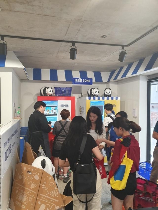지난달 28일 오후 서울 마포구 '쓰레기마트'에서 시민들이 각자 빈 캔과 플라스틱 통들을 자원순환 쓰레기통에 넣고 있다. 쓰레기마트는 쓰레기를 현금 포인트로 바꿔 매장에서 판매하는 헝겊지갑 등 친환경 제품들을 구매할 수 있다. /김승현 기자
