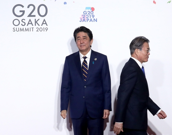 문재인 대통령이 지난 6월 28일 오전 일본 오사카에서 열린 G20 정상회의 공식환영식에서 의장국인 일본 아베 신조 총리와 악수한 뒤 이동하고 있다. /연합뉴스