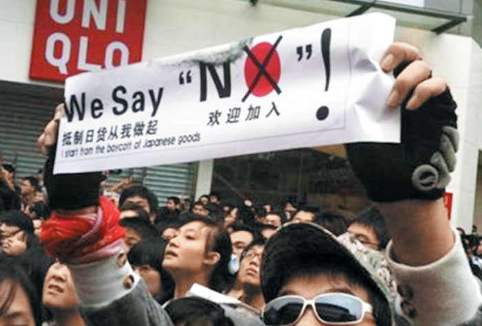 게시물 사진 속 반일 시위대는 'NO'라는 글자에서 알파벳 'O'를 붉은색으로 칠해 일장기를 연상케 하는 플래카드를 들었다.