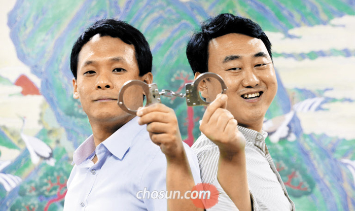 서울 국립고궁박물관에서 문화재청 사범단속반의 한상진(오른쪽) 반장과 배광훈 주무관이 수갑을 나눠 들고 포즈를 취했다. 전국을 돌며 문화재 도둑을 잡는 두 사람은 올해에만 보물 제1008호 ‘만국전도’를 비롯해 양녕대군 친필 ‘숭례문’ 목판, 전남 신안 앞바다에서 도굴된 도자기 등 굵직한 회수 실적을 냈다.