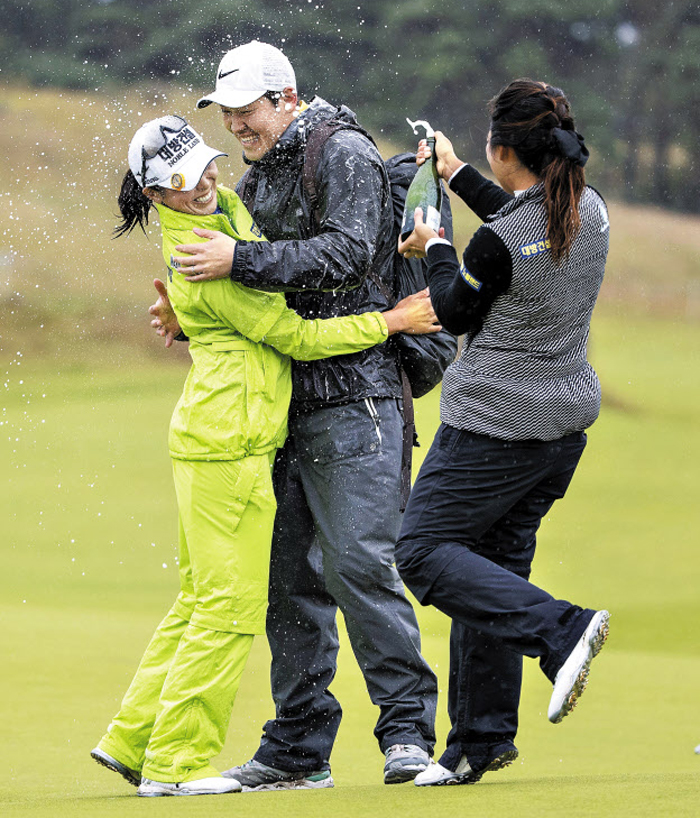 5년 만에 맛보는 승리의 샴페인은 더욱 짜릿할 듯하다. 12일 미국여자프로골프(LPGA)투어 스코티시여자오픈에서 우승한 허미정(왼쪽)이 남편과 포옹하는 순간 호주 교포 오수현이 샴페인을 터뜨리며 축하하는 모습.