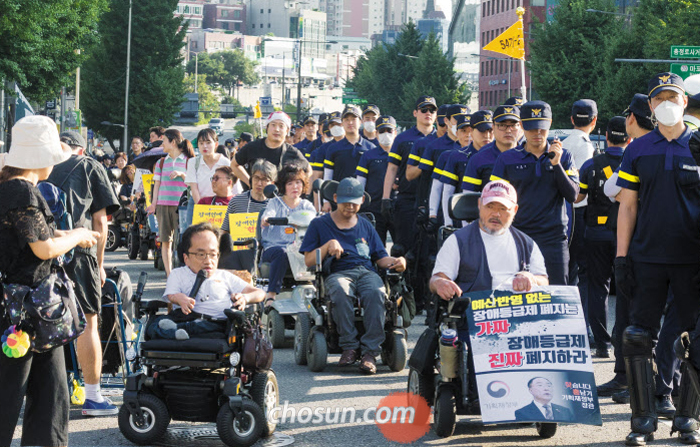 16일 오후 전국장애인차별철폐연대 회원들이 정부의 장애인 지원 예산 확충 등을 요구하며 서울 서대문구 충정로 차도를 지나고 있다. 이들은 국민연금공단 사옥 로비에서 기자회견을 연 뒤 약 3.6㎞를 행진했다.