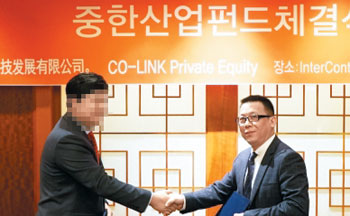 조국 법무부 장관 후보자의 5촌 조카 조모(왼쪽)씨가 지난 2016년 4월 28일 코링크프라이빗에쿼티와 중국 화군과학기술발전유한공사와의 양해각서 체결식에 나서 중국 측 대표와 악수를 나누고 있다.
