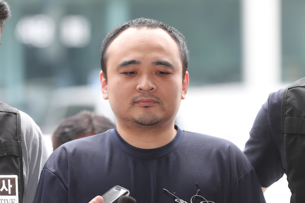 모텔 손님을 살해한 뒤 시신을 훼손해 한강에 유기한 혐의로 구속된 장대호가 21일 오후 경기 고양경찰서에서 조사를 받기 위해 이동하고 있다. /연합뉴스