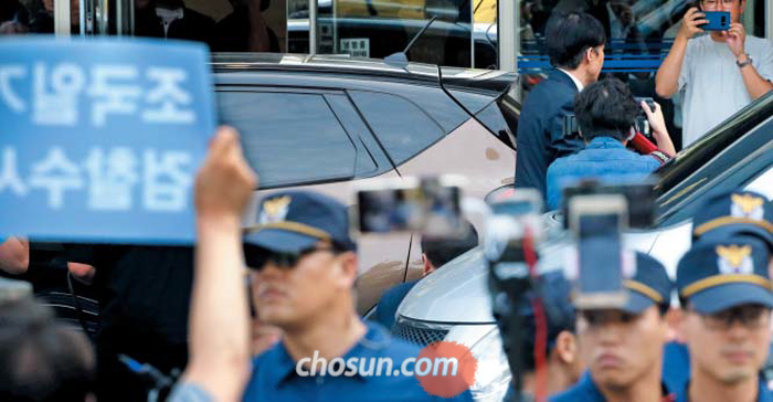 출근하는 조국… 항의하는 시민들 - 조국 법무부 장관 후보자가 22일 서울 종로구의 인사청문회 준비단 사무실에 들어서고 있다. 이날 사무실 앞에서는 조 후보자의 사퇴를 요구하는 시민단체의 기자회견이 있었고, 조 후보자는 경찰의 보호 속에 출근했다.