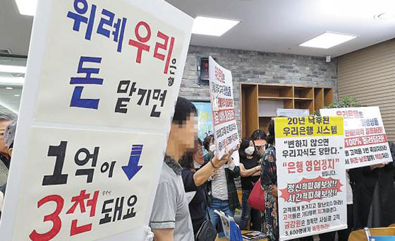 독일 국채금리 연계형 파생결합증권(DLS)에 투자했다가 거액을 날린 투자자들이 19일 오전 경기 성남시 수정구 우리은행 위례신도시지점에 몰려들어 항의 시위를 벌이고 있다.