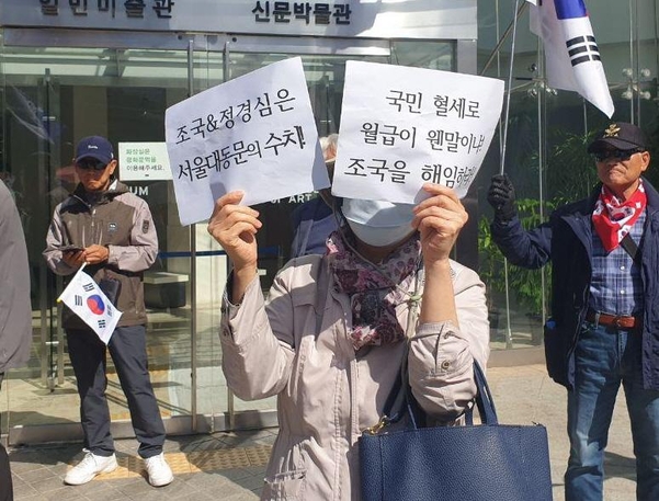 9일 서울 종로구 청계광장 앞에서 서울대의 ‘조국 반대’ 집회가 열리는 가운데, 한 참가자가 ‘조국, 정경심은 서울대 동문의 수치다’ ‘국민 혈세로 월급이 웬말이냐. 조국을 해임하라’란 문구가 쓰인 피켓을 들고 있다. /박소정 기자