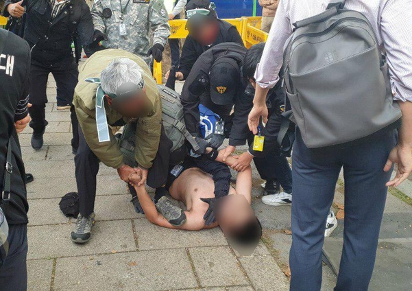 9일 오후 청와대 앞 집회 현장에서 한 20대 남성이 경찰 통제선을 넘으려다 투쟁본부 관계자들에게 제지되고 있다. /김우영 기자