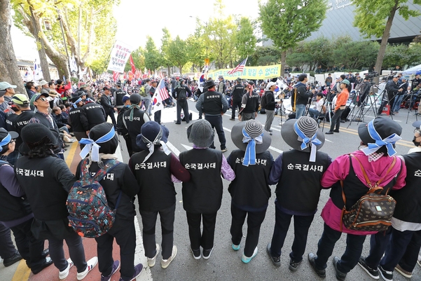 9일 오후 서울 종로구 청와대 사랑채 인근에서 조국 법무부 장관 사퇴 촉구 집회 참가자들이 만일의 사태를 대비해 자체적으로 질서유지선을 만들었다. /연합뉴스