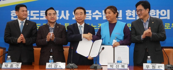 9일 국회에서 열린 한국도로공사 요금수납원 현안 합의 서명식에서 이강래 한국도로공사 사장과 박선복 한국도로공사톨게이트노조 위원장이 악수하고 있다. (왼쪽부터) 김경욱 국토교통부 제2차관, 박홍근 을지로위원장, 이강래 사장, 박선복 위원장, 우원식 을지로위원회 의원. /연합뉴스