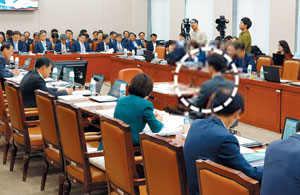 속기사 경쟁률 73대1 지난 14일 국정감사장에 앉아 있는 속기사(하얀 동그라미 점선). 국회 사무처는 보통 매년 7~8월 ‘9급 공개경쟁채용시험’을 통해 속기사 5명가량을 뽑는다. 올해 속기직 경쟁률은 73.5대1. 봉급은 일반 9급 공무원과 같이 170만원대다. 속기 직렬 출신 가장 높은 직급은 의정기록심의관(3급)이지만, 5급부터는 공석이 생길 때만 올라갈 수 있어 6급에서 정년을 맞는 경우가 많다. /이영빈 기자