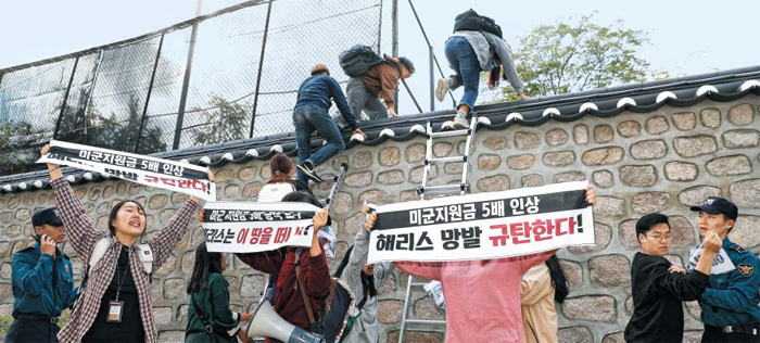 18일 오후 3시쯤 친북 단체인 한국대학생진보연합(대진연) 회원들이 서울 중구 정동 주한 미국대사관저 담장에 사다리를 대고 관저 안으로 넘어들어가고 있다. 현장에 있던 경찰은 대진연 회원에게 붙들려 저지당하거나(오른쪽 끝) 무전으로 지원 요청하느라(왼쪽 끝) 이들의 월담을 제지하지 못했다. 관저에 기습 침입한 이들은 관저 현관까지 올라가 반미 플래카드를 펼치고 구호를 외쳤다. 