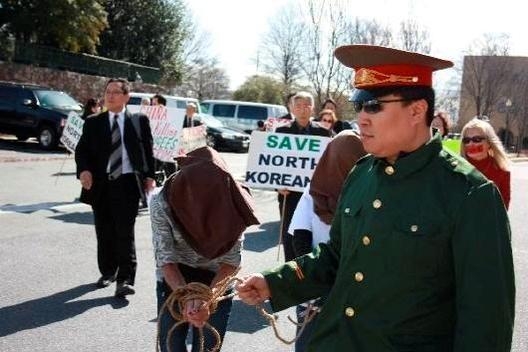 탈북자 강제북송에 항의하는 미국 인권단체들이 2012년 3월 주미 중국 대사관 앞에서 벌인 시위에서 중국 공안 복장을 한 한 참가자가 얼굴을 가린채 포박을 한 여성들을 끌고가고 있다. /조선DB