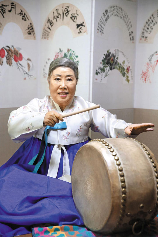 남색 치마·옥빛 저고리를 입은 신영희 명창이 자택 안방에 놓인 병풍 앞에 앉았다.