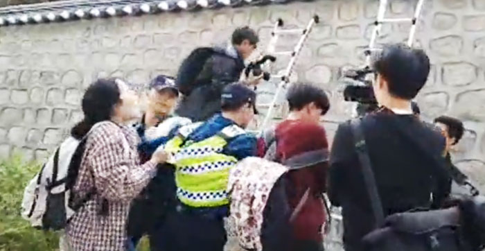 지난 18일 서울 중구 주한 미국 대사관저로 담을 넘어 침입하려던 한국대학생진보연합의 여성 회원(맨 왼쪽)이 이들을 저지하려는 경찰을 뒤에서 잡아당기고 있다.