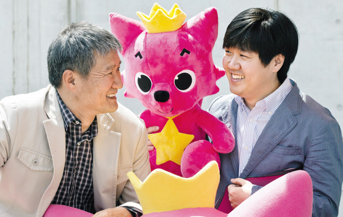 핑크퐁 캐릭터를 가운데 두고 마주 앉은 스마트스터디의 김민석(오른쪽) 대표와 아버지 김진용(왼쪽) 삼성출판사 대표.