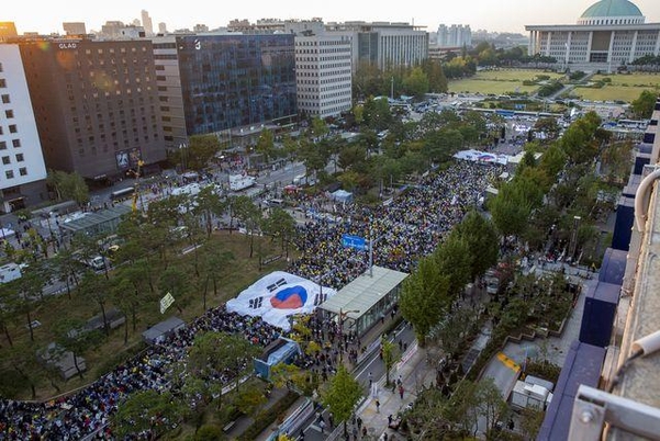 지난 19일 서울 여의도 국회앞에서 공수처 설치를 요구하는 촛불 집회가 열린 가운데 대형 태극기가 지나가고 있다. / 조인원 기자