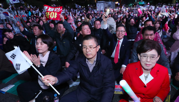 자유한국당 황교안 대표와 전희경(왼쪽)·최연혜(오른쪽) 의원이 25일 오후 서울 광화문광장에서 문재인하야범국민투쟁본부 주최로 열린 제3차 범국민투쟁대회에 참가해 태극기를 흔들고 있다. /연합뉴스