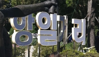 ’아베규탄부산시민행동’ 회원들이 30일 오전 부산 동구 초량동 정발장군 공원 안 화단에 ‘항일거리’ 현판을 설치한 뒤 선포식 집회를 갖고 있다. 이들은 “불법행위”라는 사실을 고지하고 제지에 나선 동구 측과 경찰들을 힘으로 밀어붙인 뒤 현판을 설치했다. /부산경찰청 제공