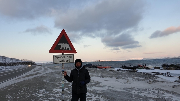 북극곰 출몰 주의 경고판을 붙잡고 있는 기자. 스발바르 전 지역에 이 경고가 적용된다./ 조홍복 기자