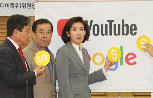 자유한국당 나경원(오른쪽) 원내대표가 지난달 24일 국회 의원회관에서 열린 '유튜브 노란딱지, 무엇이 문제인가' 간담회에서 우파 유튜브 채널에 집중적으로 붙어 피해가 발생한다는 '노란딱지'의 모형을 들고 있다./연합뉴스