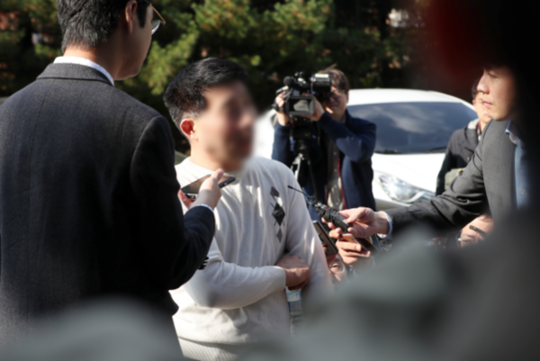 화성 연쇄살인 8차 사건의 범인으로 지목돼 20년을 복역한 뒤 억울함을 호소하고 있는 윤모씨가 지난달 30일 오후 경기도 수원시 장안구 경기남부지방경찰청 광역수사대에 참고인 조사를 위해 출석하며 취재진의 질문에 답하고 있다. /연합뉴스