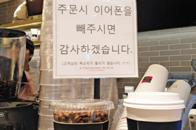 13일 서울 강남구 한 카페에 “주문 시 이어폰을 빼주시면 감사하겠습니다”라는 문구가 붙어 있다.