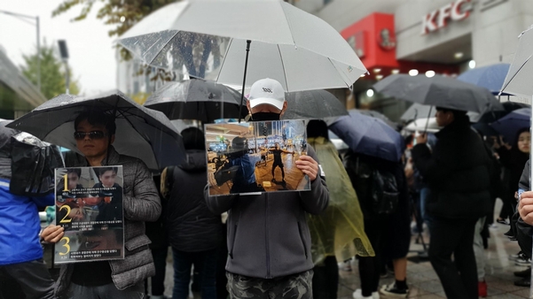 17일 오후 서울 마포구 홍대입구역 9번 출구 앞에서 ‘홍콩 민주주의를 지지하는 시민 모임’ 소속 회원이 홍콩 시위대와 관련된 사진을 들고 있다. /이은영 기자