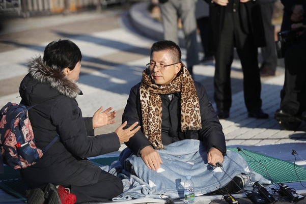 자유한국당 황교안(오른쪽) 대표가 20일 청와대 앞 분수대에서 목도리를 건넨 시민과 대화하고 있다./연합뉴스