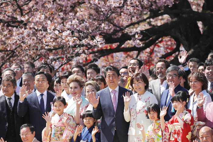 Abe信條(の中) 日本総理と奥さんあきに(Abe右側) 女史が去る 4月東京にある国立公園新宿校には(新宿御苑)で開かれた総理主観の ‘桜を見る集まり’に参加して参加者達と一緒に手を振って記念写真を撮影している. 