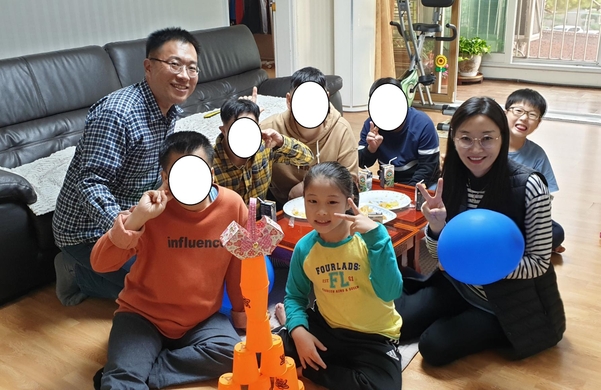 광주광역시 북구 운암동 한 장애인거주시설을 최근 찾은 김용식, 박경화씨 가족. 자녀 김정민군과 김서연양이 발달장애인과 플라스틱 컵쌓기 놀이를 하고 있다./ 김용식씨 제공