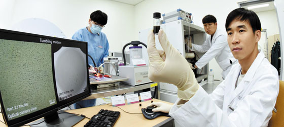 최은표 한국마이크로의료로봇연구원 연구부장(전남대 기계공학부 교수) 연구진이 암 진단과 치료를 동시에 하는 나노로봇을 개발했다. 연구원이 나노로봇 입자가 들어 있는 용액을 들어 보이고 있다.
