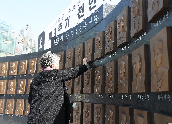 3월 26일 경기도 평택시 해군 제2함대 사령부에서 열린 제9주기 천안함 46용사 추모식에서 한 유가족이 추모비에 새겨진 얼굴을 어루만지고 있다./연합뉴스 