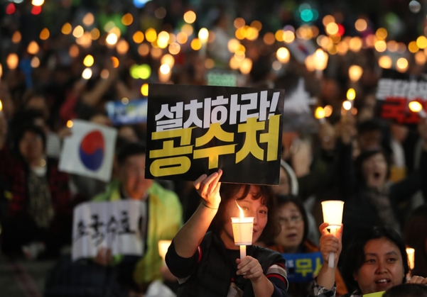 지난 10월 23일 조국 전 법무장관 아내 정경심씨의 구속영장 기각을 촉구하는 촛불집회에 참가한 시민들이 시민들이 조국 수호와 공수처 설치 피켓을 들고 있다. / 연합뉴스