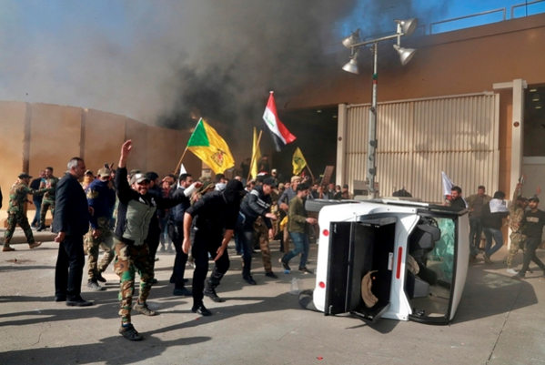  이라크 내 친이란 시아파 민병대 카타이브-헤즈볼라를 폭격한 미국에 항의하는 시위대가 31일(현지시간) 바그다드 주재 미 대사관에 진입, 기물을 부수고 불을 지르고 있다. /AP 연합뉴스