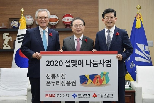 빈대인 부산은행장이 13일 오전 신정택 부산사회공동모금회장과 오거돈 부산시장에게 지역 소외게층의 ‘따뜻한 설나기’를 돕기 위해 전통시장 온누리상품권 4억원어치를 전달하고 있다. /부산시제공