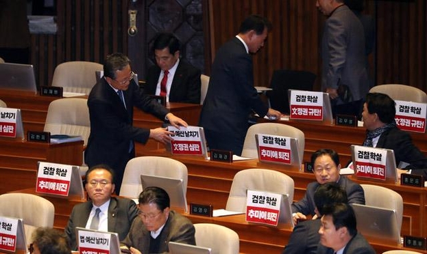  자유한국당 의원들이 13일 본회의장 의석에 '검찰 학살, 문정권 심판' '추미애 퇴진' 등이 적힌 피켓을 붙이고 있다./연합뉴스