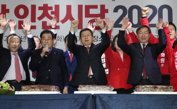 자유한국당 황교안(가운데) 대표가 14일 오후 인천 남동구 인천로얄호텔에서 열린 한국당 인천시당 신년인사회에서 기념떡을 자른 뒤 참석자들과 함께 만세를 외치고 있다./연합뉴스