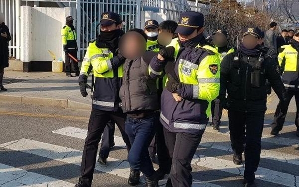14일 서울 종로구 정부서울청사 앞에서 천막 철거를 막고 자해를 시도한 탈북민 이모(46)씨가 경찰에 연행되고 있다. /독자 제공