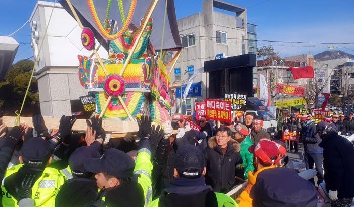 16일 충남 태안군청 앞에서 어민 200여 명이 상여를 메고 태안군청 진입을 시도하며 경찰과 맞서고 있다. 어민들은 모항항 서쪽 25㎞ 해상에 건립을 추진하는 해상 풍력발전 단지가 생계를 위협할 수 있다고 주장한다.