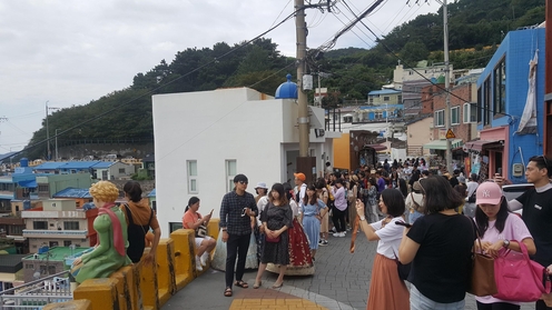 지난 여름 부산 사하구 감천2동 감천문화마을을 찾은 관광객들이 이 마을의 상징이 된 어린왕자 조형물 주변에서 사진 촬영을 하고 있다./사하구 제공