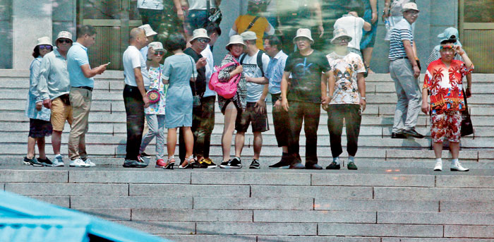 2018년 7월 판문점 북측 지역 앞에서 북한을 관광 중인 관광객들이 판문점 남측 지역을 보고있다.