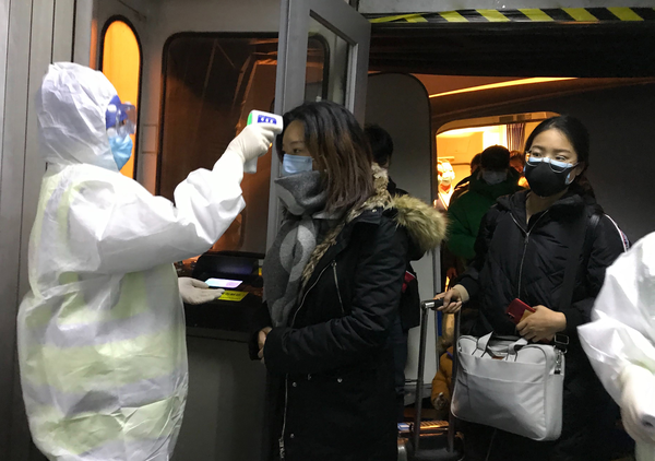 22일 중국 베이징 공항에서 방호복을 입은 검역관이 신종 코로나바이러스가 시작된 우한에서 출발해 들어오는 승객들의 체온을 측정하고 있다. /연합뉴스