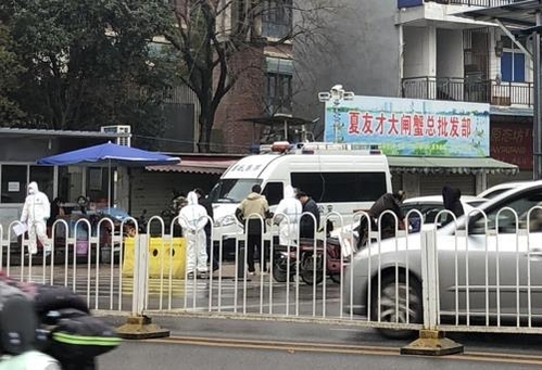 지난 21일 오후 중국 후베이성 우한(武漢)시의 화난(華南)수산물도매시장 입구에서 흰 방역복을 입은 중국 보건 당국 관계자들이 분주히 오가고 있다. /연합뉴스