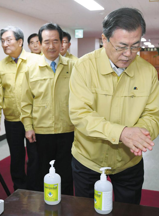 문재인(맨 오른쪽) 대통령이 30일 오전 정부서울청사에서 열린 '우한 폐렴(신종 코로나 바이러스 감염증)' 대응 종합 점검회의에 입장하면서 세정제로 손을 닦고 있다.