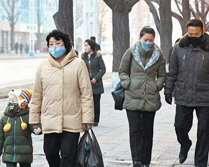 북한 주민들이 마스크를 쓰고 걸어가고 있다. 