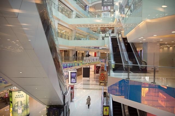 마스크를 쓴 한 여성이 지난 4일 고객의 발길이 끊겨 텅빈 중국 베이징의 한 쇼핑몰 안을 걸어가고 있다. /연합뉴스